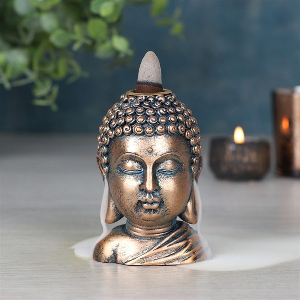 Intricately designed Buddha Head Incense Burner placed on a meditation table.