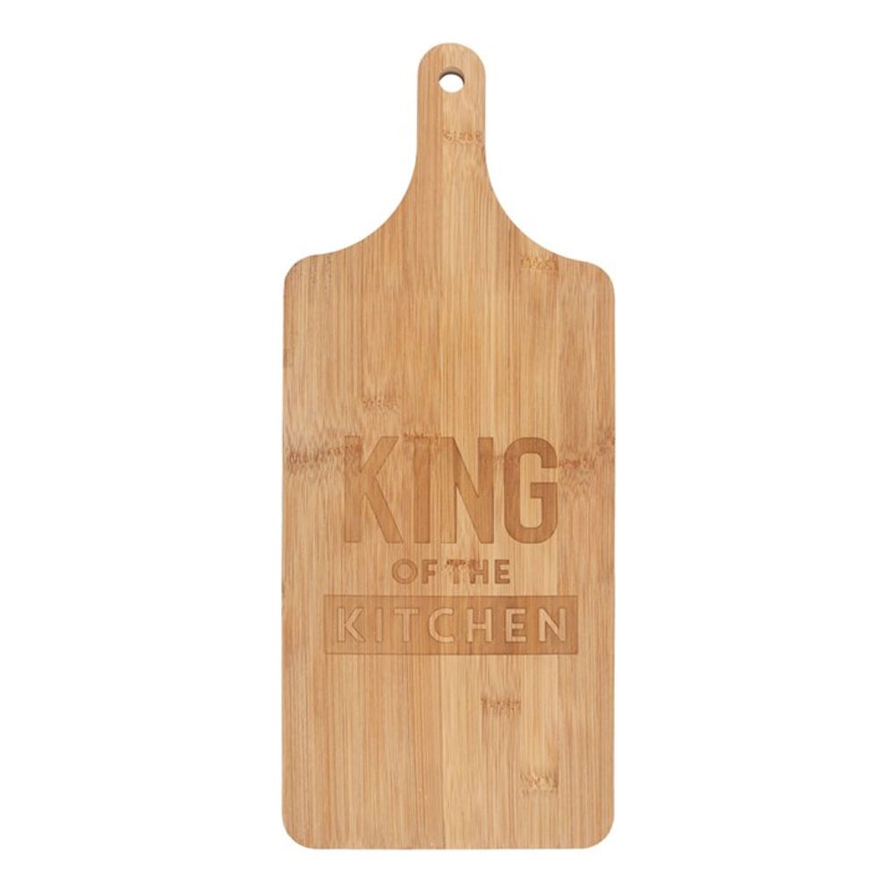 Bamboo paddle chopping board engraved with 'King of the Kitchen' alongside freshly chopped vegetables.