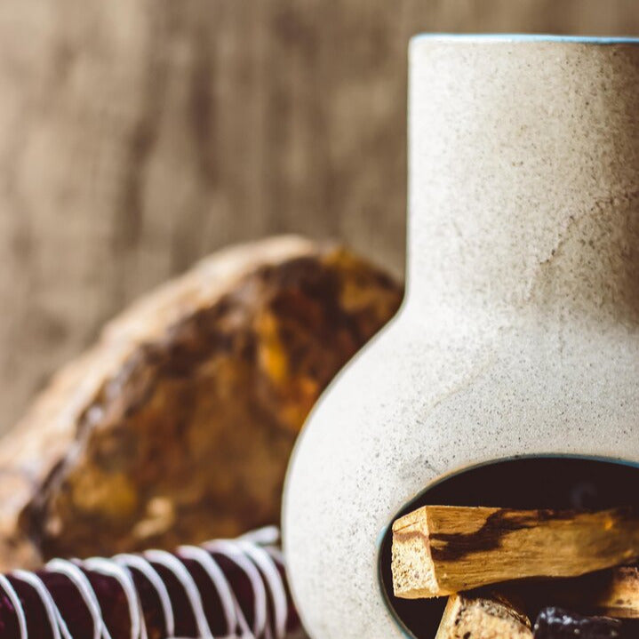 Miniature chiminea with sage bundle and soft natural light