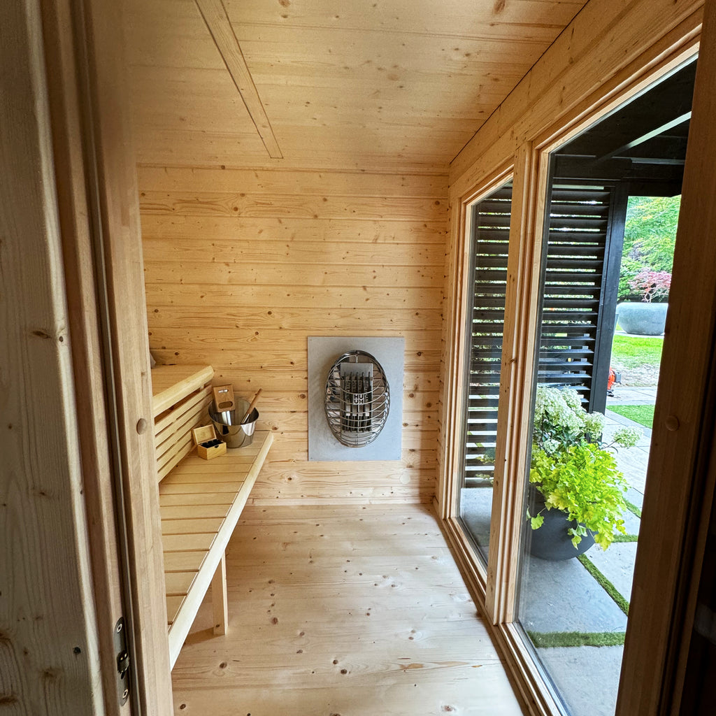 Interior view of dual-zone sauna with aspen benches and panoramic tempered glass window