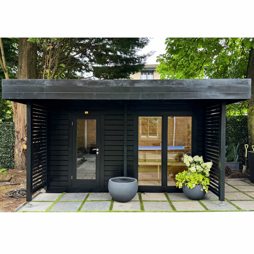 Black outdoor Sauna/ Cold Plunge Thermal Therapy Suite with glass doors in a garden setting.