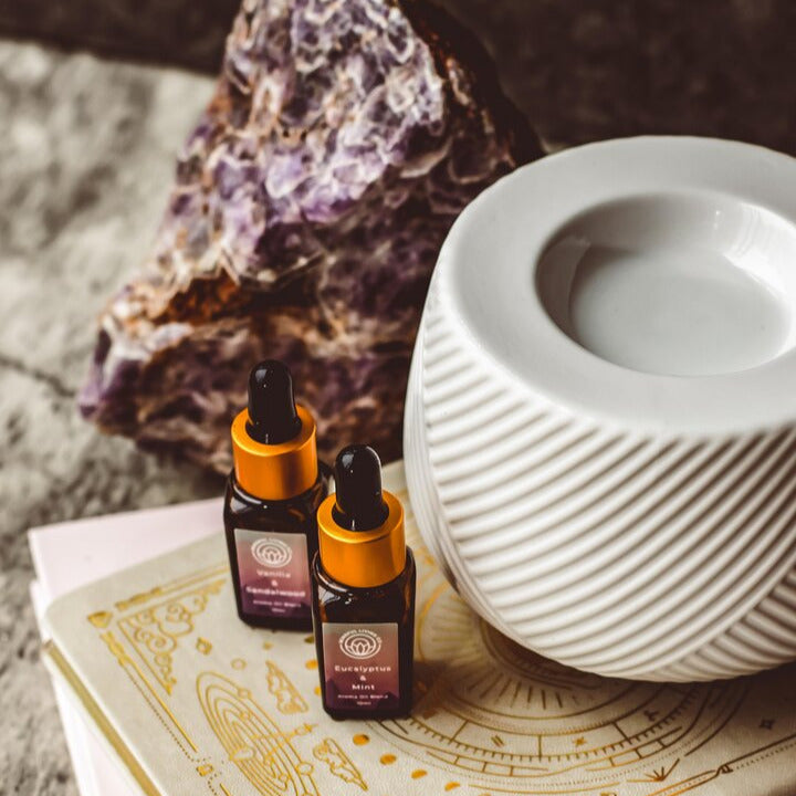 Close-up of textured diagonal pattern on ceramic oil warmer accompanied by 2 premium essential oil fragrances. 