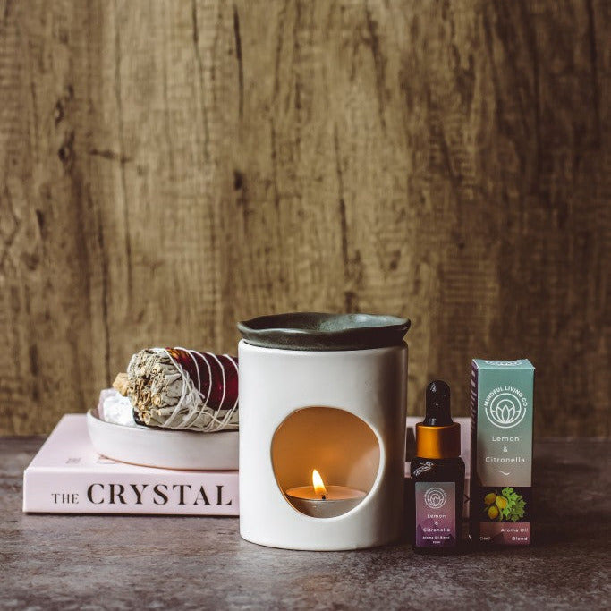 Lemon & Citronella diffuser oil beside candle burner and sliced citrus – bright, clean, and uplifting.