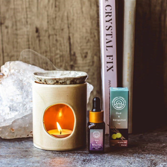 Oud & Bergamot oil bottle with dark citrus and glowing oil burner – smoky, rich, and serene.