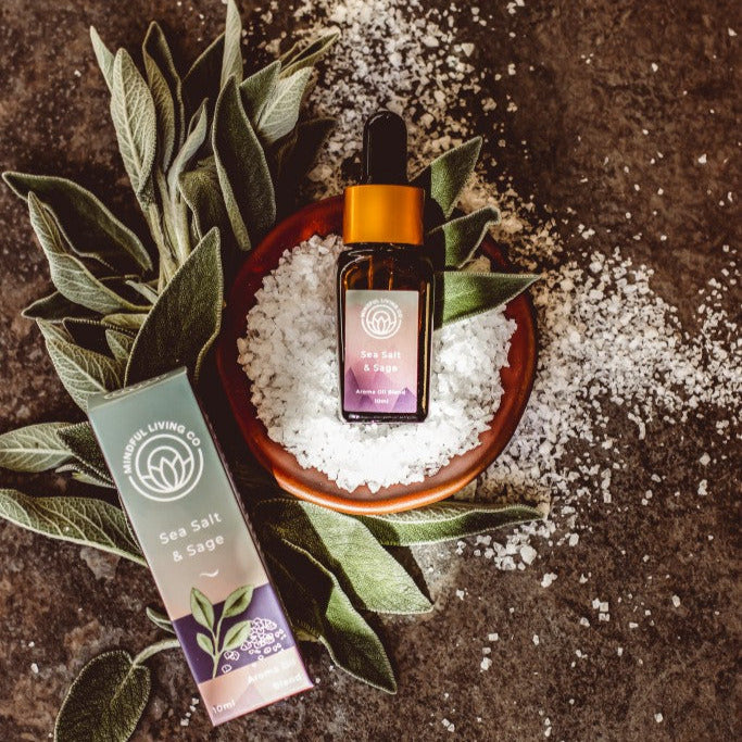 Sea Salt & Sage fragrance oil near coarse salt, sage sprigs, and burner – airy and herbal.
