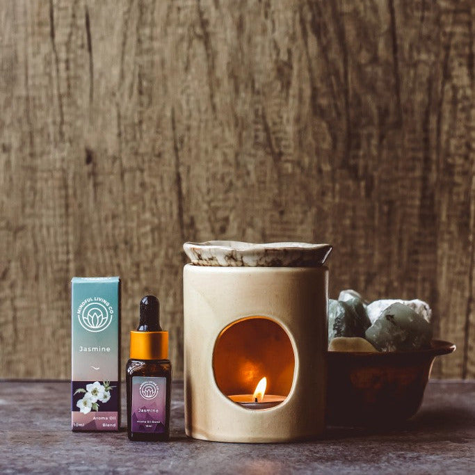 Jasmine scented oil bottle with delicate petals and glowing burner – calming and elegant.