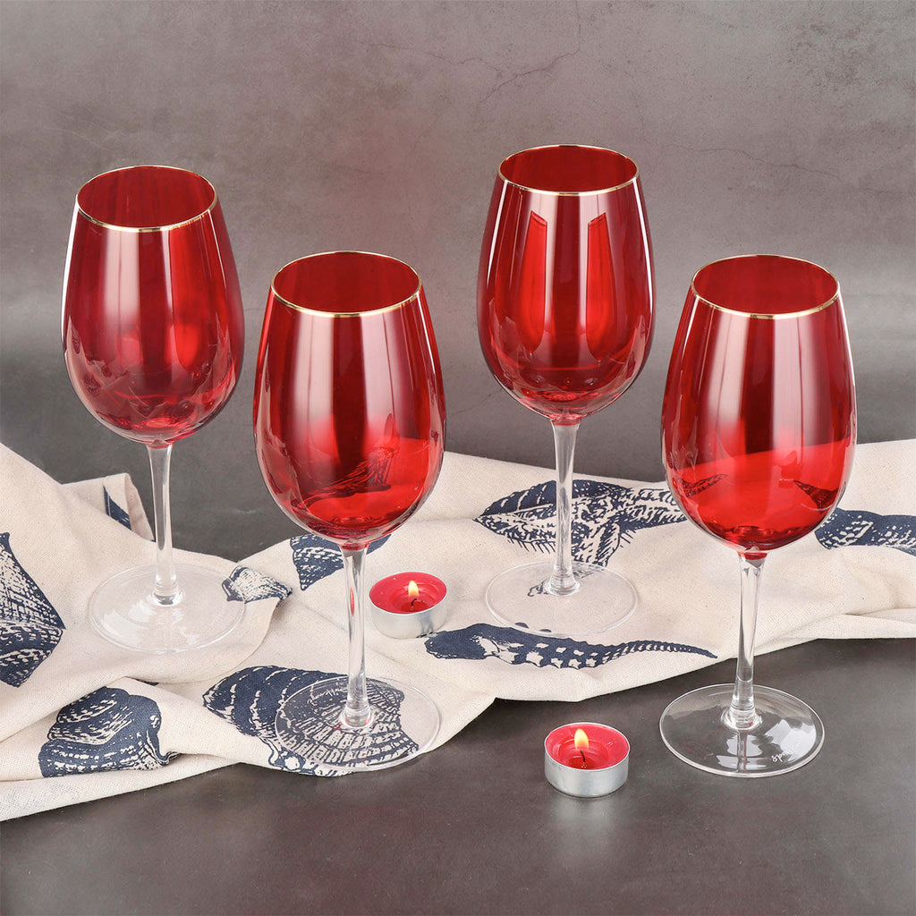 A set of four Sparkleware large red wine glasses, elegantly rimmed with golden rim, presented on a luxurious table setting. 