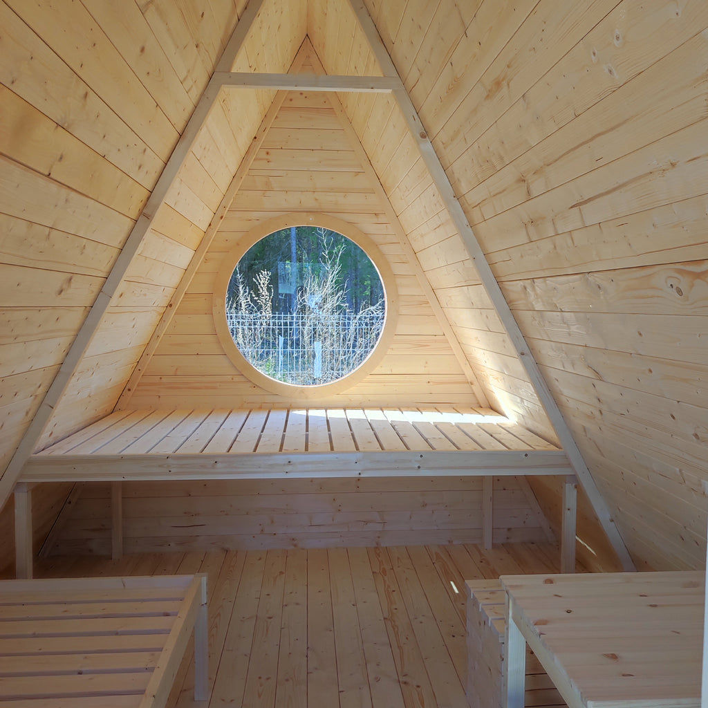 Interior view of the Wigwam, showcasing the plush double bed, fold-out table, and additional beds.