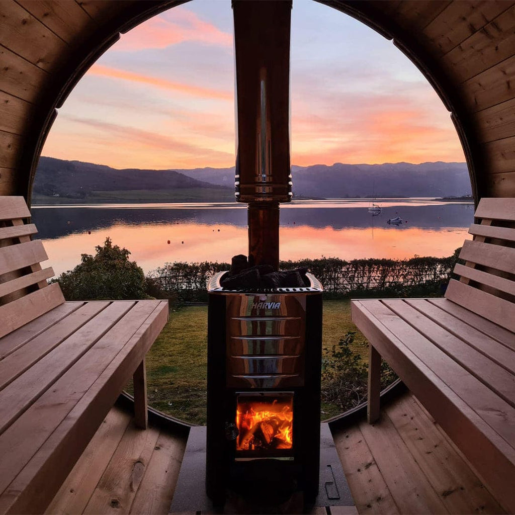 Inside view of the spacious barrel sauna, showcasing its long benches and impeccable Thermowood craftsmanship.