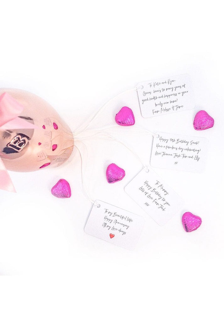 Rose Pink Sparkleware Gin Glasses filled with gin and tonic, with Belgian Milk Chocolate Pink Foiled Hearts on the side.