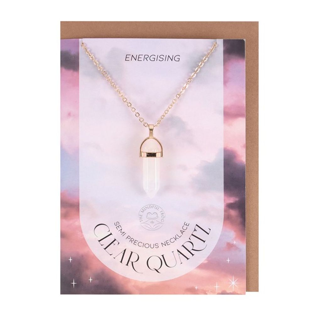 Gold-tone necklace with clear quartz crystal pendant on blank greeting card.