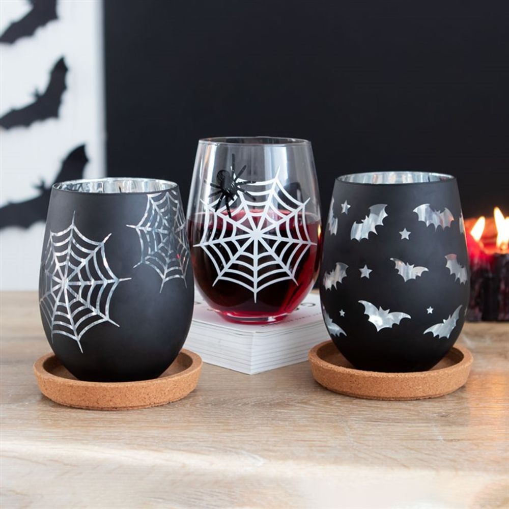 Complete set of the stemless wine glasses, showcasing the contrasting designs - clear with spider and black with shimmering silver web.